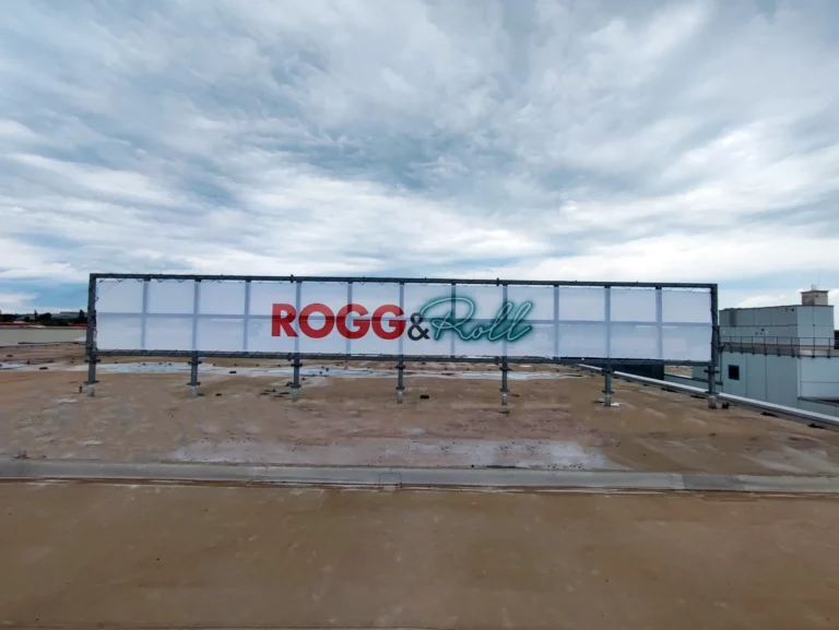 Blog 21 Bannerwerbung: Möbel Rogg Banner auf dem Dach mit Rohrrahmen.